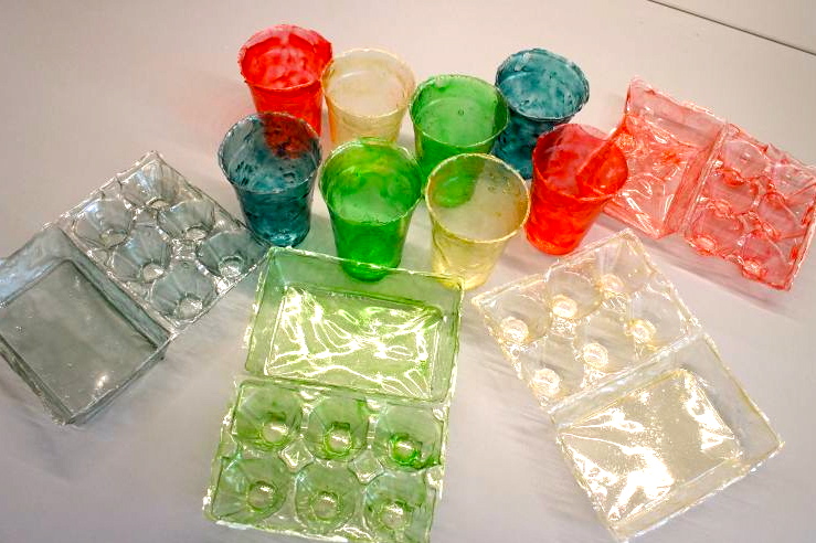 The chitosan bioplastic can be modified for use in water and easily dyed by changing the acidity of the chitosan solution. The dyes used to color these plastic cups and egg cartons can be collected during the recycling process for reuse. (Wyss Institute)