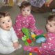 Three toddler triplets sitting on rug