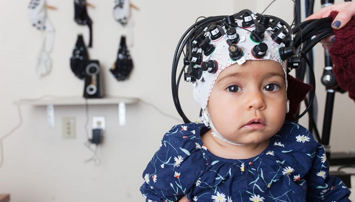 An infant in the Functional Near-Infrared Spectroscopy neuroimaging lab. (Kathleen Krol)