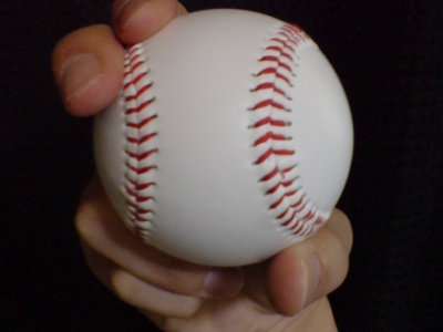 Close up of hand holding baseball in curve ball pitch grip