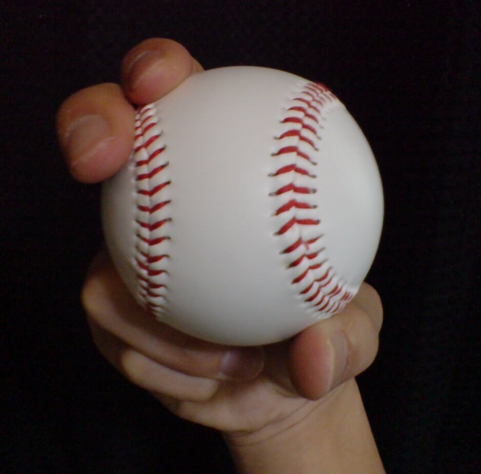 Close up of hand holding baseball in curve ball pitch grip